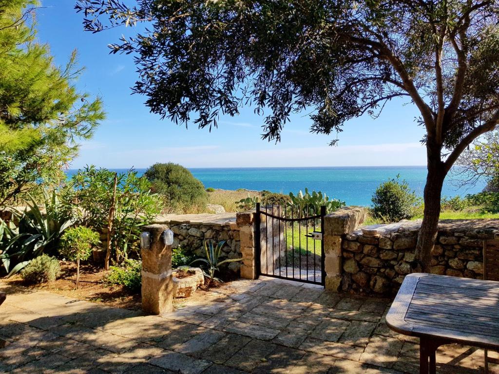 une porte menant à une terrasse avec l'océan en arrière-plan dans l'établissement Villa Tina ai Piedi del Faro di Leuca, à Leuca