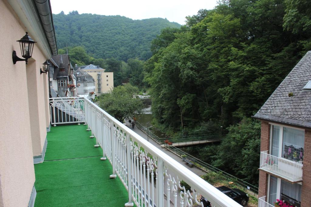 a balcony with green flooring and a view of a river at Posthotel in Bad Bertrich