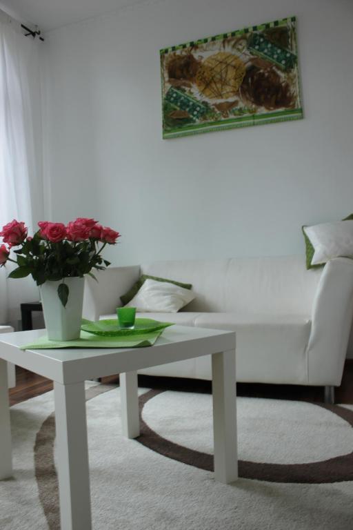 a white coffee table with a vase of flowers on it at FeWo Kerstin Rossbacher in Solingen