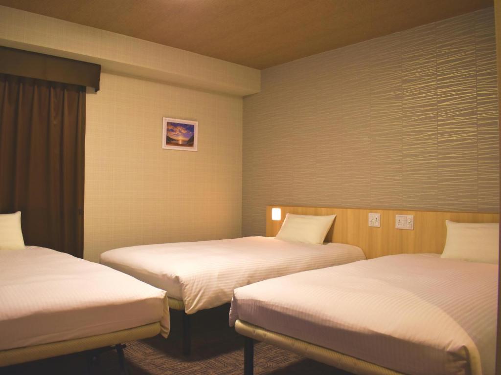 Postel nebo postele na pokoji v ubytování TABINO HOTEL Sado