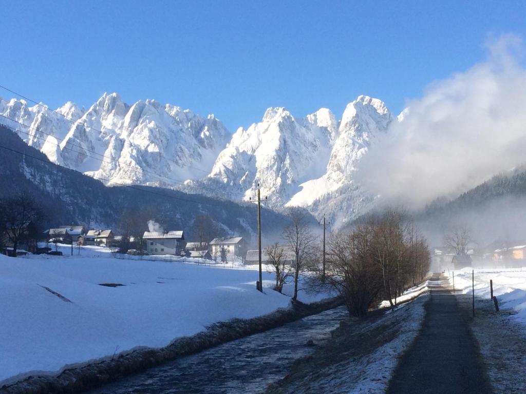 a snow covered mountain range with a road in front at Dachstein Mountainview Gosau in Gosau