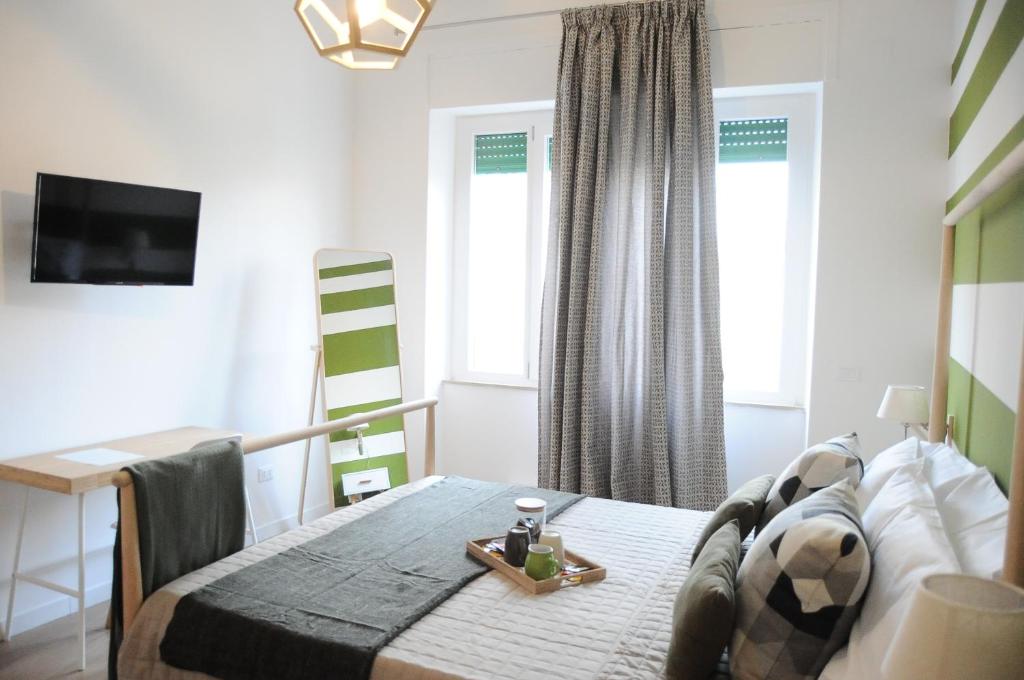 - une chambre avec un lit, une table et un bureau dans l'établissement The Corner 180 Suite, à Cosenza