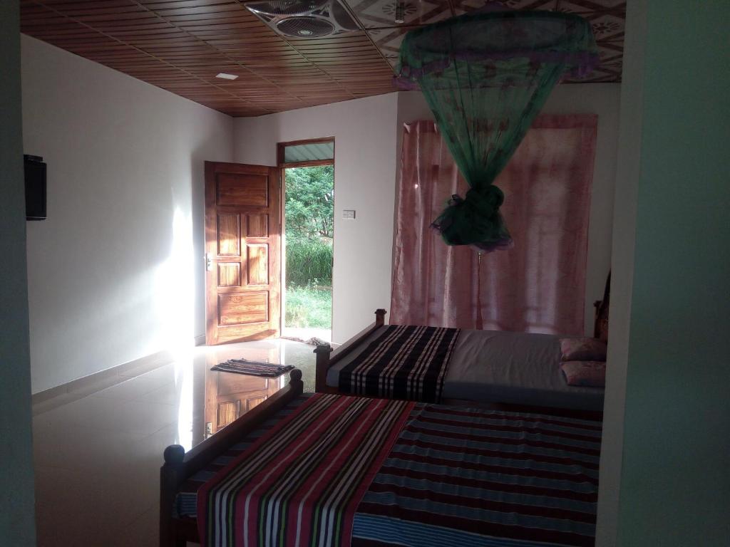 1 dormitorio con cama, ventana y puerta en Wilpattu buma, en Nochchiyagama