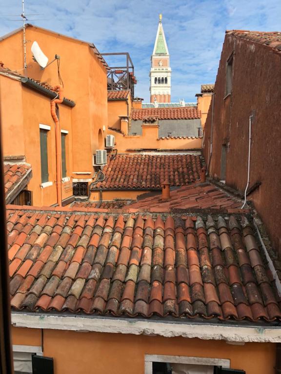 vista su un tetto con torre dell'orologio sullo sfondo di Corte Contarina a Venezia