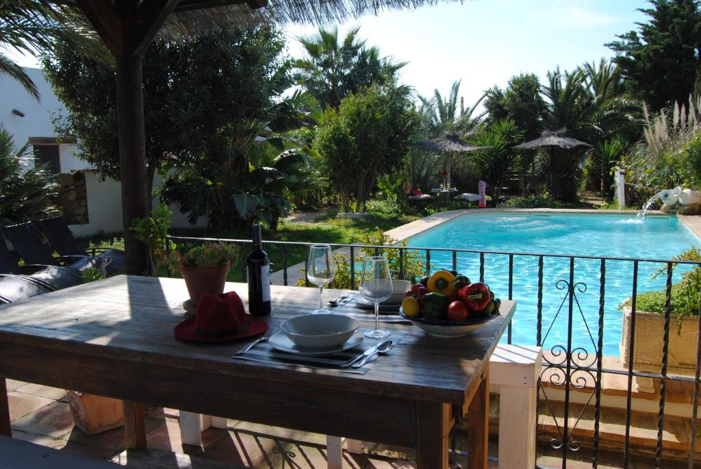 a table with a bowl of fruit next to a swimming pool at Casa Entre Armonías in Zahara de los Atunes