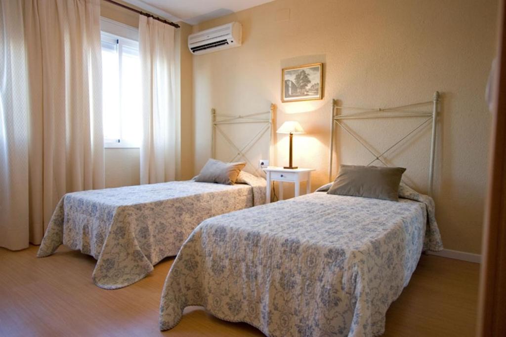 1 dormitorio con 2 camas y ventana en Macarena Flat, en Sevilla