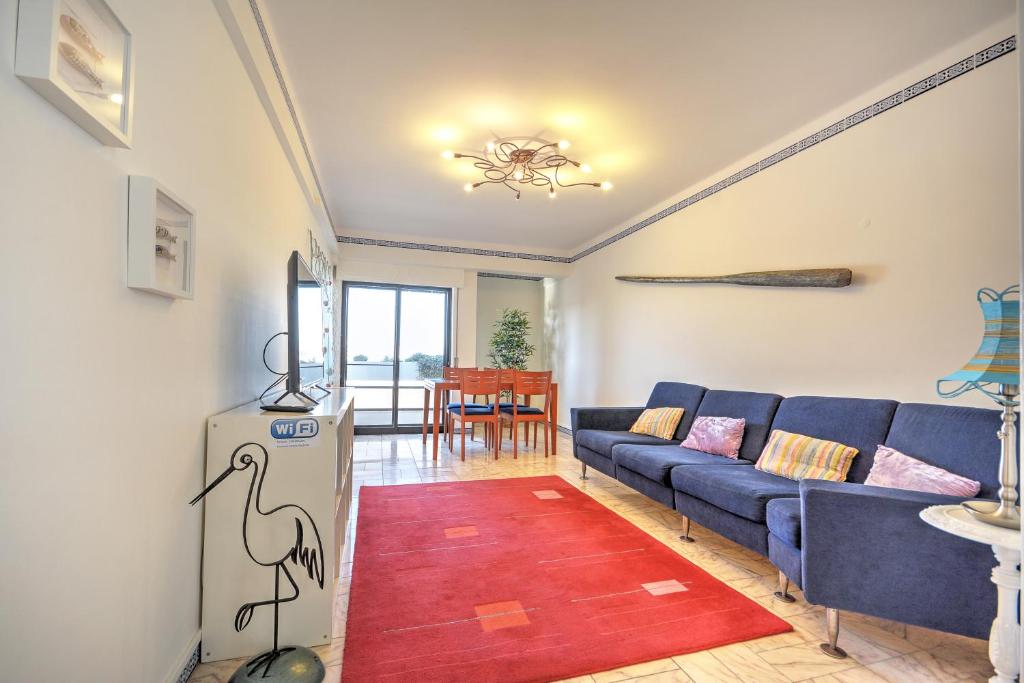 un soggiorno con divano blu e tappeto rosso di In Faro with Sea View a Faro