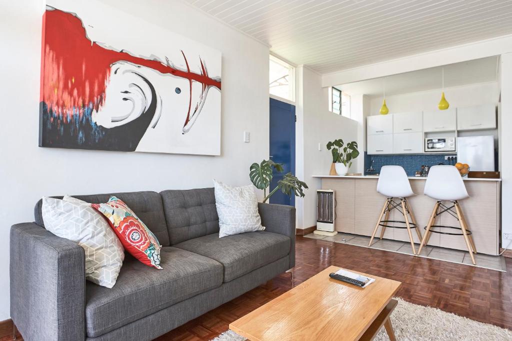 uma sala de estar com um sofá e uma mesa em House Sandrock Muckleneuk Selfcatering apartment em Pretoria