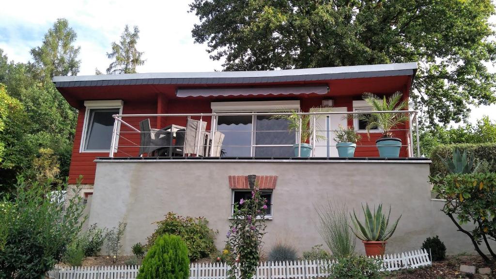 een rood huis met een balkon erop bij Bungalow Thiele in Döbeln