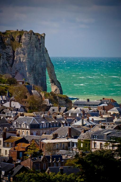 a town with houses and a mountain in the background at Domaine Saint Clair - Le Donjon in Étretat