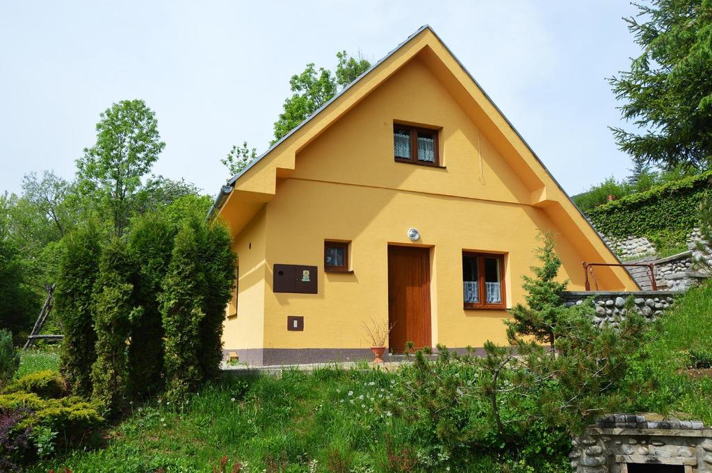 ein gelbes Haus mit einem Strohdach in der Unterkunft Chata Kubko in Bobrovník