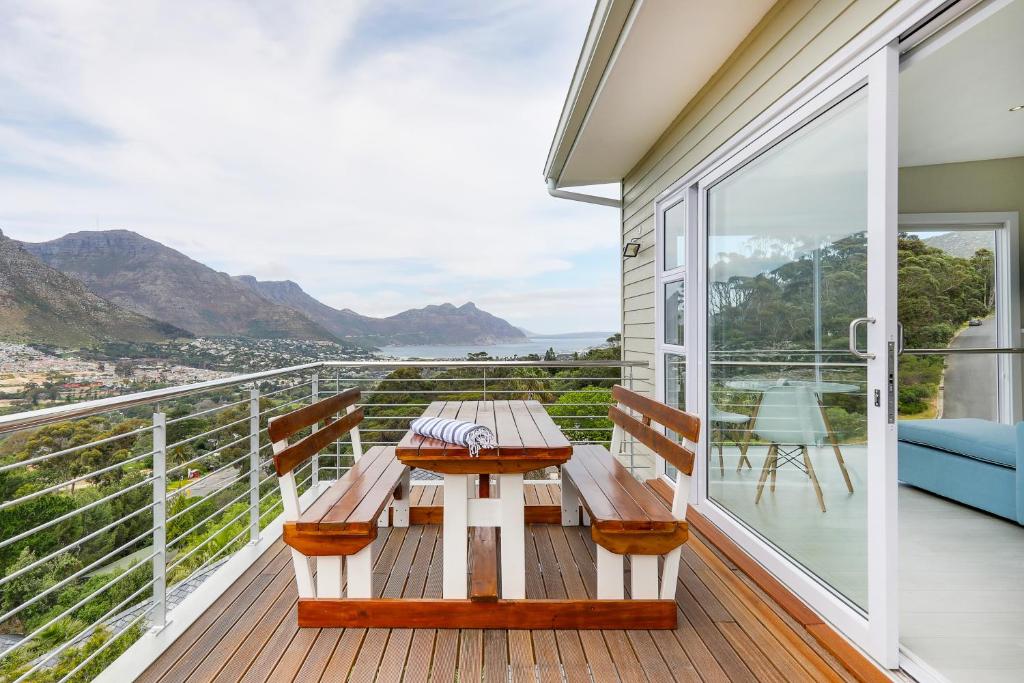 a porch with a wooden table and chairs on a balcony at Mount Bay in Hout Bay