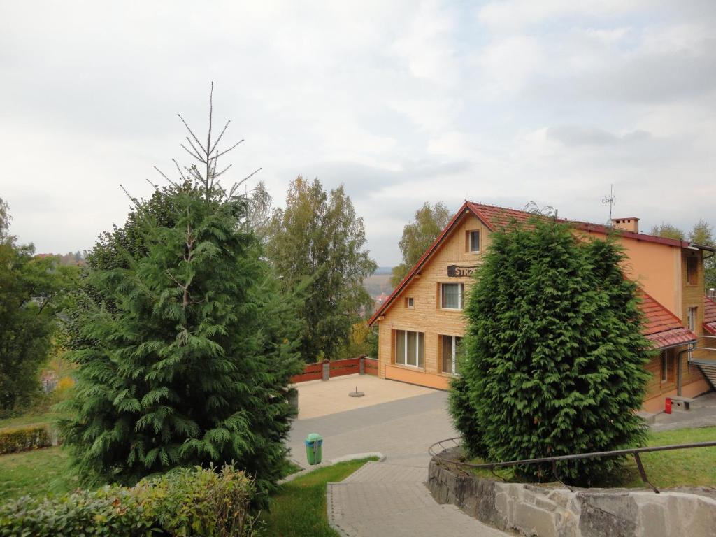 ein Haus mit zwei Bäumen davor in der Unterkunft O.W.S. Strzecha in Duszniki-Zdrój