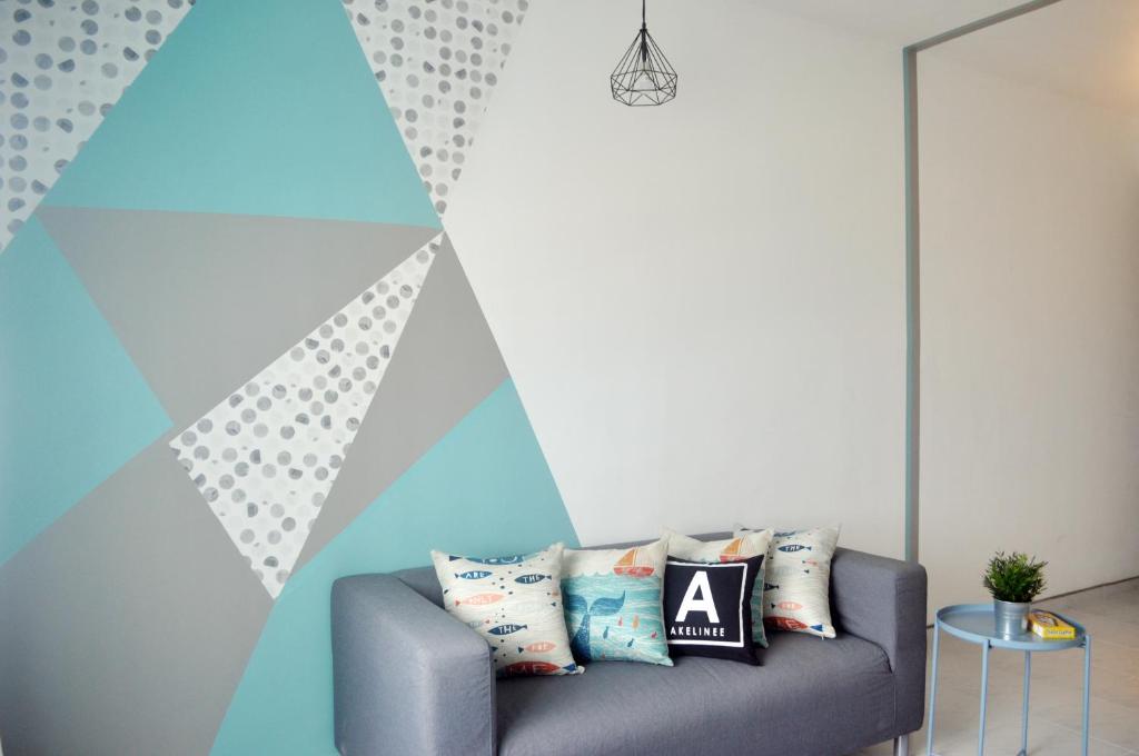 ein Sofa in einem Zimmer mit einer geometrischen Wand in der Unterkunft Seaview Akelinee Apartment 3 in Kuala Terengganu