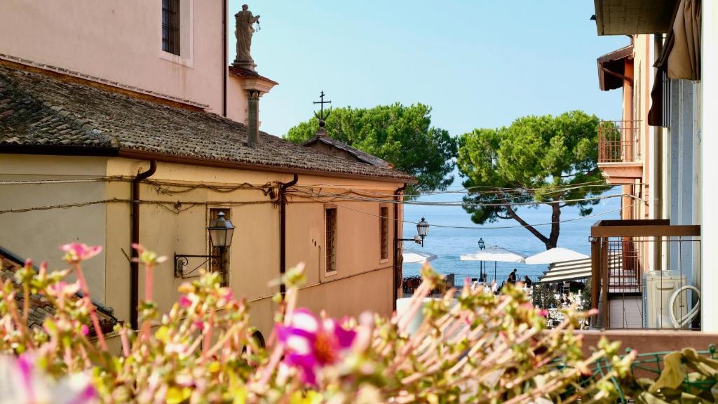 a building with pink flowers in front of it at Boutique Apartment Cà Tulles in Torri del Benaco