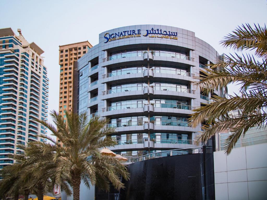 Un grand bâtiment avec un panneau en haut dans l'établissement Signature Hotel Apartments and Spa, à Dubaï