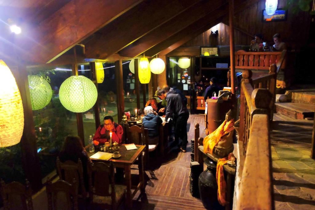a group of people sitting at tables in a restaurant at Hotel At The End Of The Universe in Nagarkot