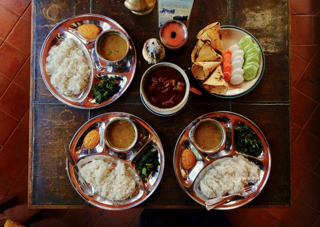 a table with four plates of food on it at Hotel At The End Of The Universe in Nagarkot