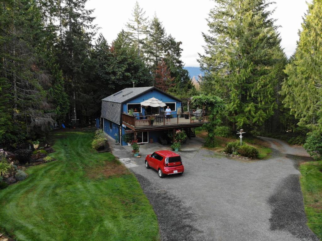 una vista aérea de una casa con una furgoneta roja estacionada en la entrada en Beaver Hut Bed And Breakfast, en Port Alberni