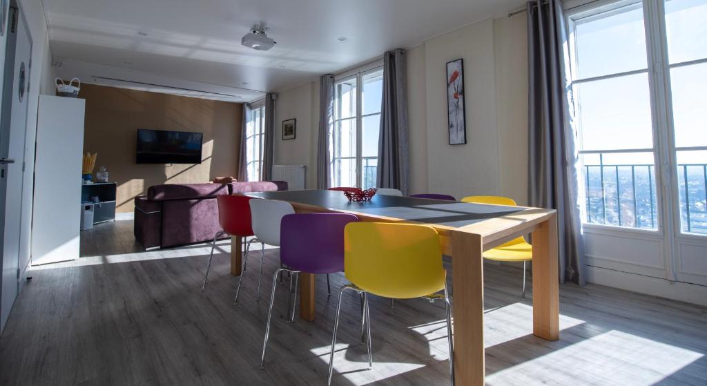 亞眠的住宿－Le 360 TOUR PERRET 19eme PANORAMA 4 ETOILES，一间配备有桌子和五颜六色椅子的用餐室