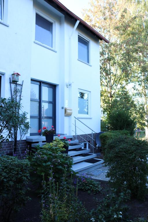 une maison blanche avec des escaliers en face de celle-ci dans l'établissement Ferienwohnung Seestern in Steinhude, ruhig gelegen , 2 Schlafzimmer, 2 Bäder, Freies WLAN, à Wunstorf