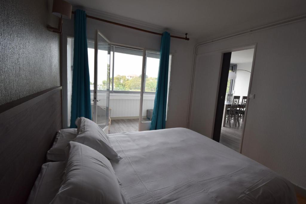 a bedroom with a bed and a large window at Hôtel Beau Rivage in Royan