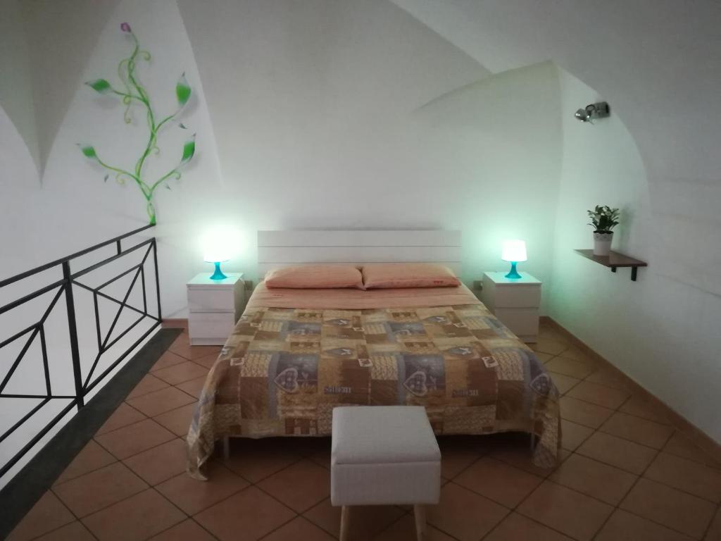 ナポリにあるAppartamento ai Tribunaliのベッドルーム1室(ベッド1台、2つのテーブルに照明付)