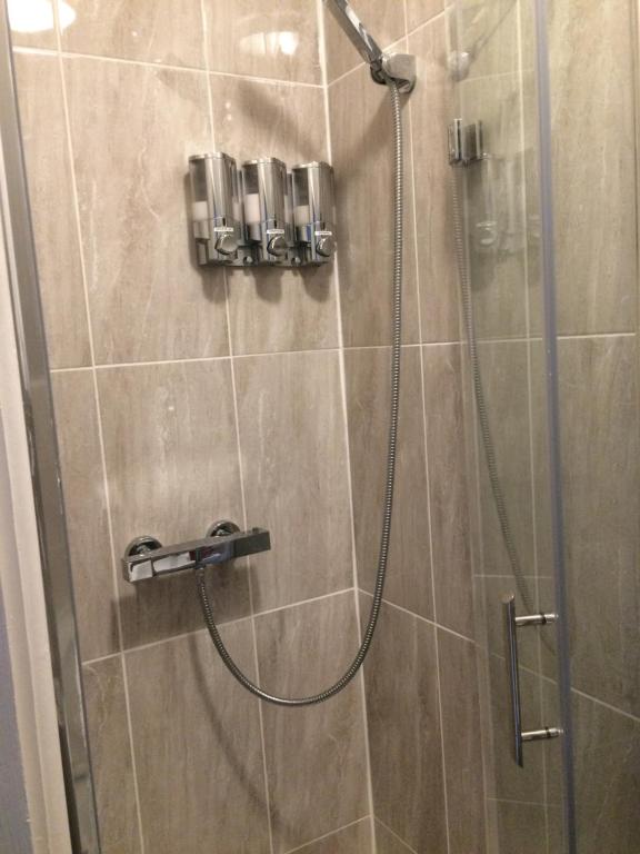 y baño con ducha y puerta de cristal. en simply guesthouse, en Londres