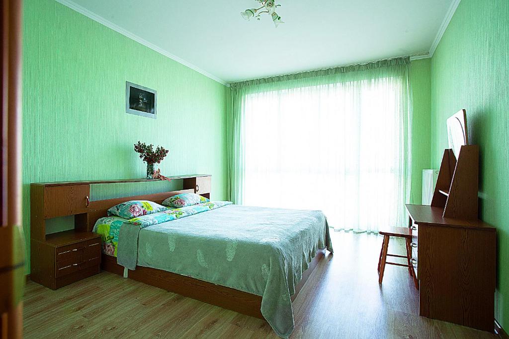 カリーニングラードにあるApartment on Gorkogoの緑のベッドルーム(ベッド1台、窓付)