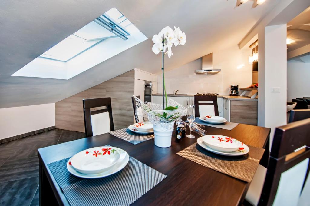 jadalnia z drewnianym stołem z czerwonymi kwiatami w obiekcie Apartments Centener w Rovinj