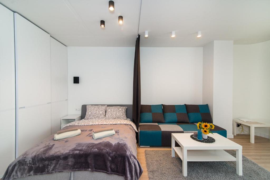 ein Schlafzimmer mit einem Bett, einem Sofa und einem Tisch in der Unterkunft Vilnius City Centre apartment in Vilnius