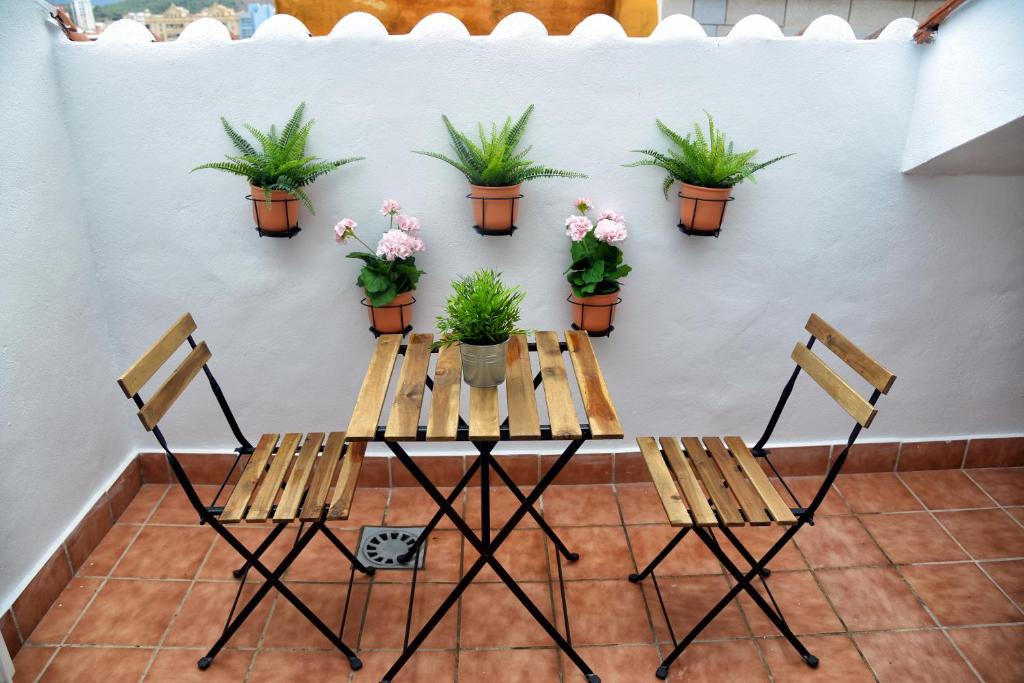 マラガにあるApartamentos Maribelの鉢植えのテーブルと椅子