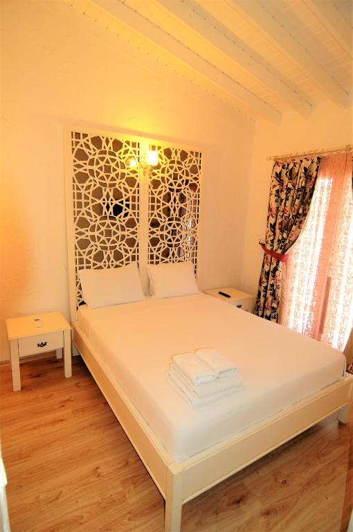 A bed or beds in a room at Alacati Eldoris Butik Hotel