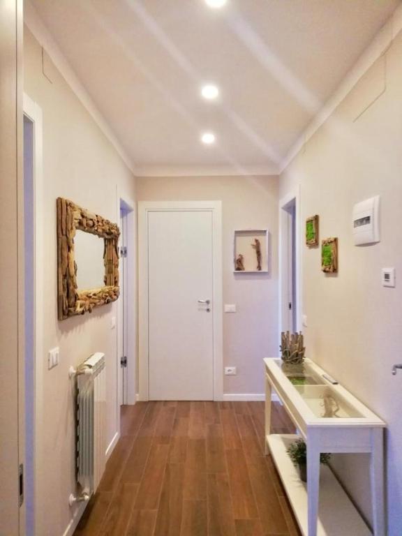 Una habitación blanca con una mesa y un espejo. en Bixio Suites, en La Spezia