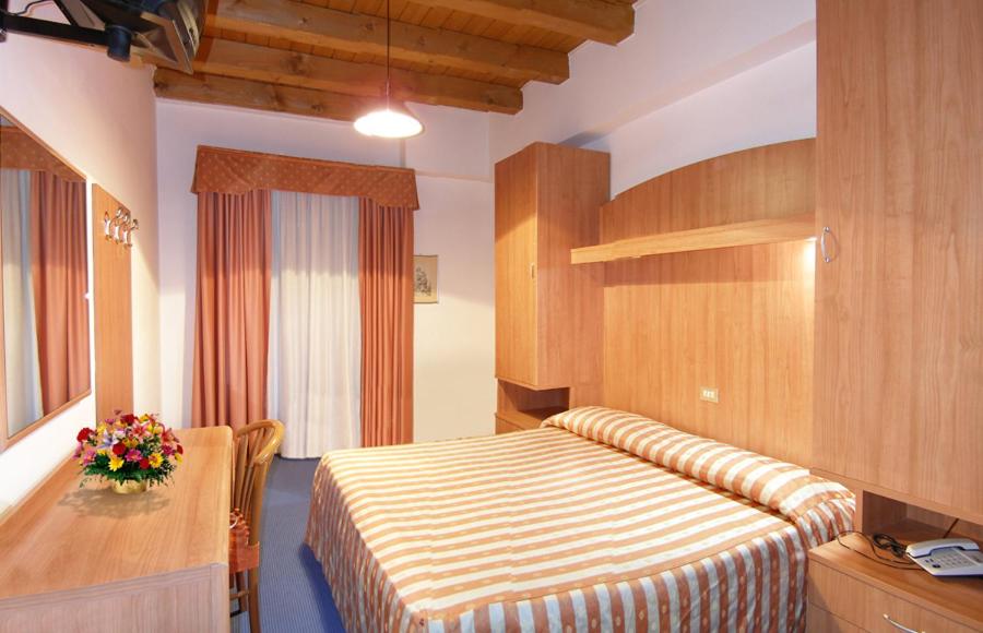 una camera d'albergo con letto e scrivania di Hotel Da Bepi a Lido di Jesolo