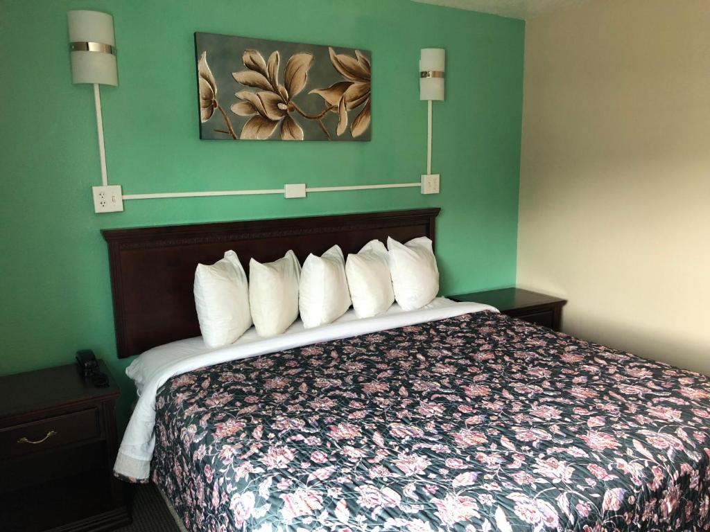 Habitación de hotel con cama con almohadas blancas en Midtown Inn, en Springfield