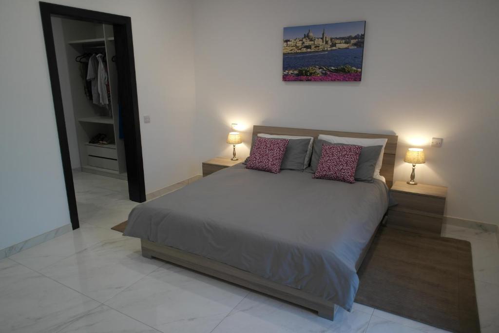 1 dormitorio con 1 cama con 2 lámparas en Marsaskala Penthouse Apartment, en Marsaskala