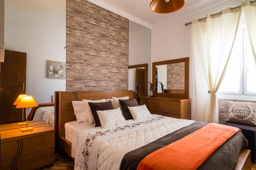 um quarto com uma cama e uma parede de tijolos em Dream city home 2 em Caldas da Rainha