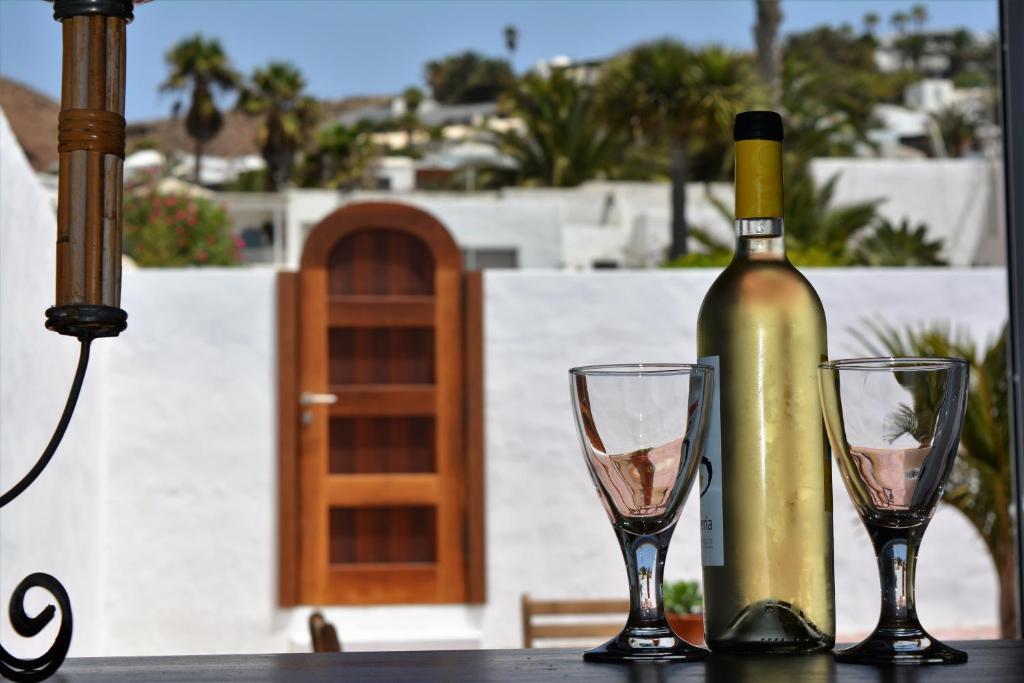 a bottle of wine and two glasses on a table at Apartamento Las Palmeras Nazaret in Nazaret