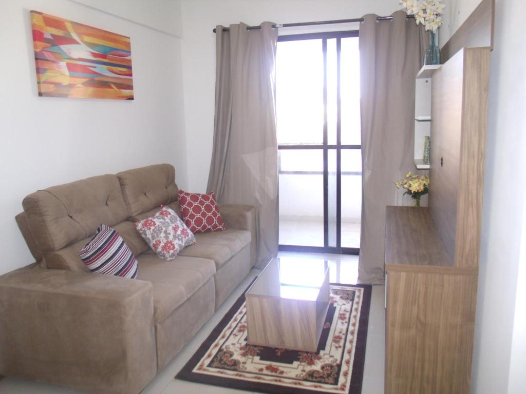 uma sala de estar com um sofá e uma mesa em Apartamento 3/4 completo em frente ao Aeroporto em Salvador