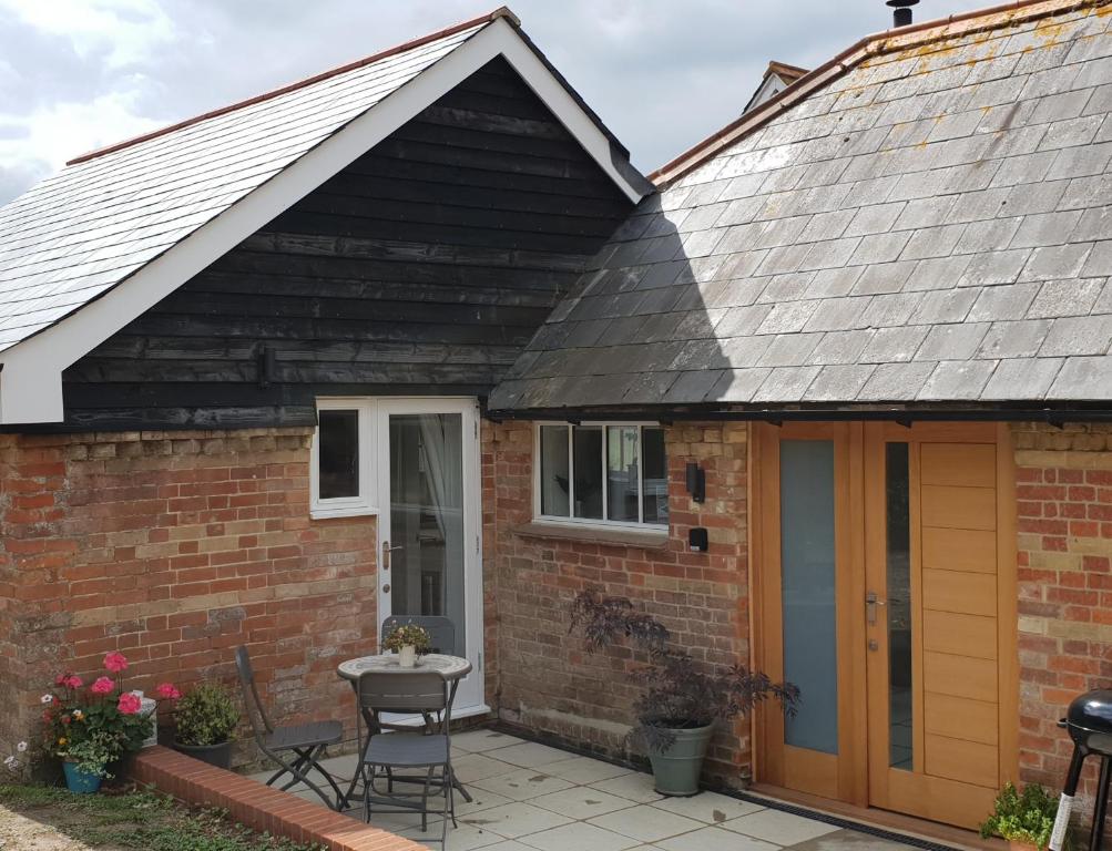 a house with a pitched roof and a patio at Alberts Dairy Cottage in East Cowes