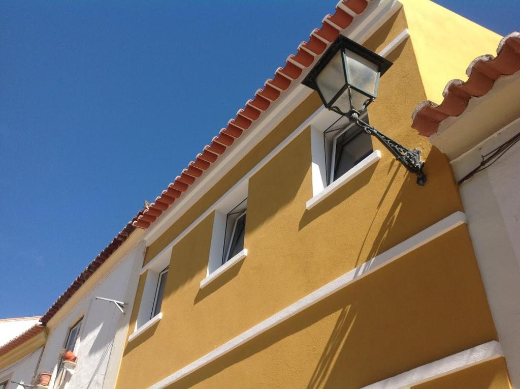 a yellow building with a street light on it at Casa da Barca in Abrantes