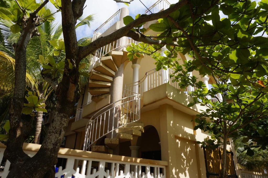a building with stairs and trees in the foreground at Ramaya Auberge Espagnole in Grand-Popo