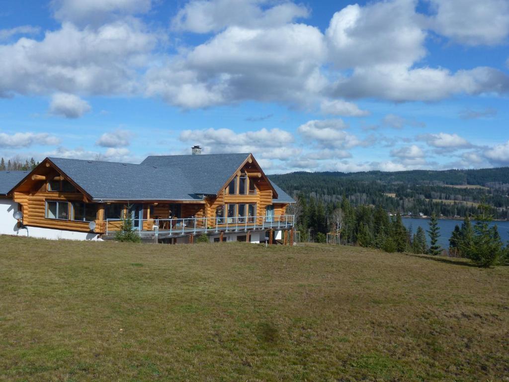 a large log house on top of a hill at Little Black Bear Lodge/B&B in Bridge Lake