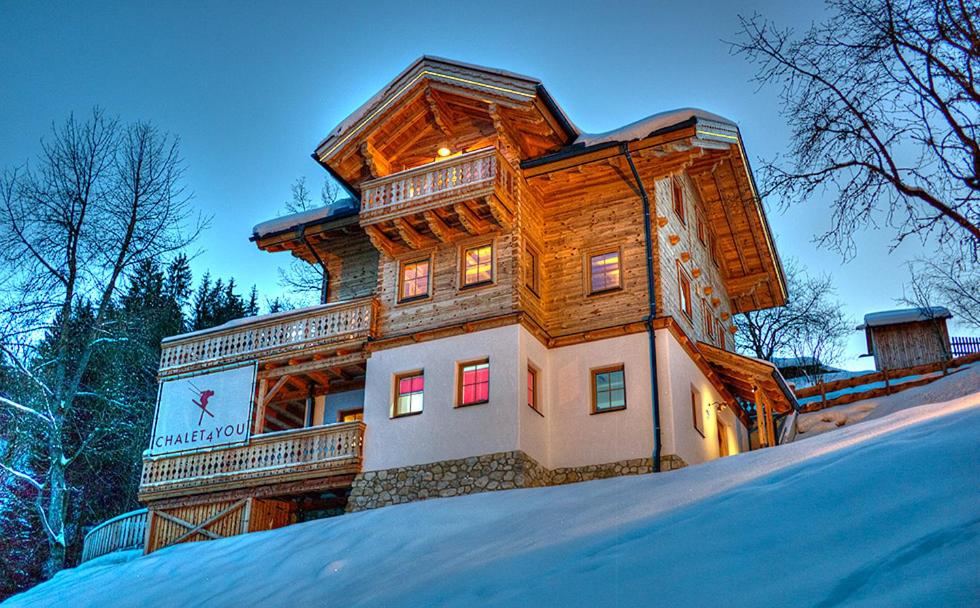 ハウス・イム・エンスタールにあるChalet4Youの雪面の上に建つ大きな木造家屋