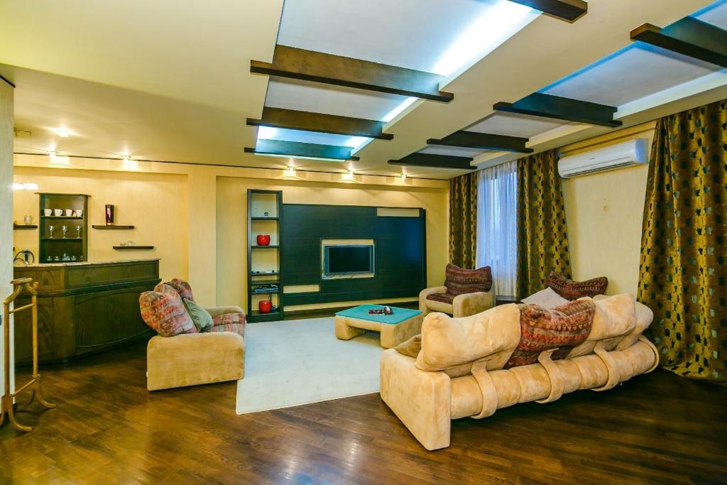 ein großes Wohnzimmer mit Sofas und einem TV in der Unterkunft 4 Bedrooms Beautiful City Center in Baku