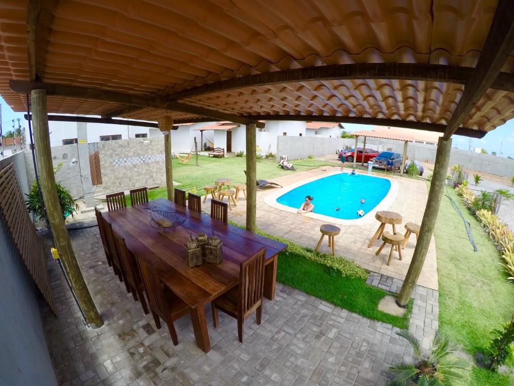 vistas a un patio con mesa y piscina en Pousada Pedra da Baleia, en São Miguel do Gostoso