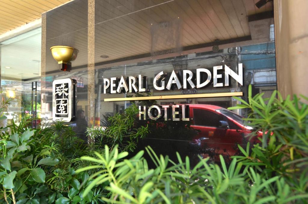 a sign for a hotel with a car in the window at Pearl Garden Hotel in Manila