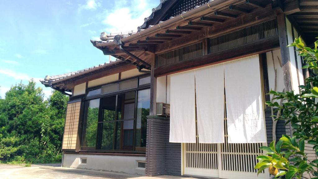 a house with a white curtain on the side of it at 一棟貸し平戸よこた in Hirado