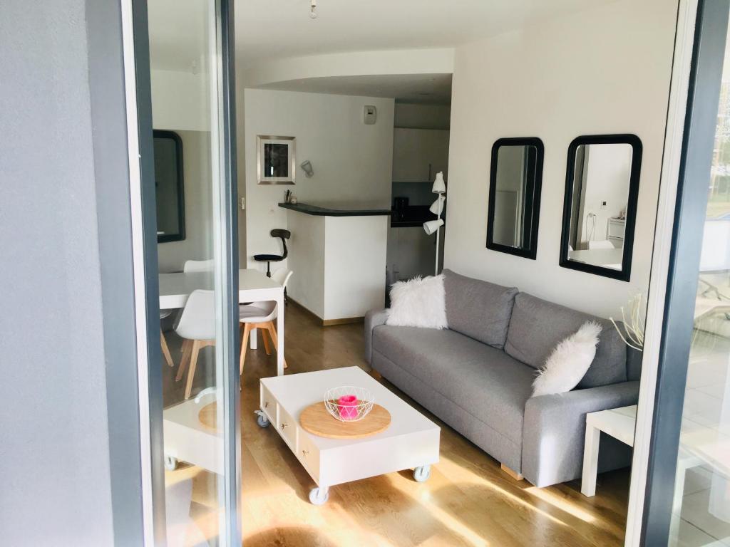 ein Wohnzimmer mit Sofa und Tisch in der Unterkunft Appartement Les terrasses Saint-Malo in Saint-Malo